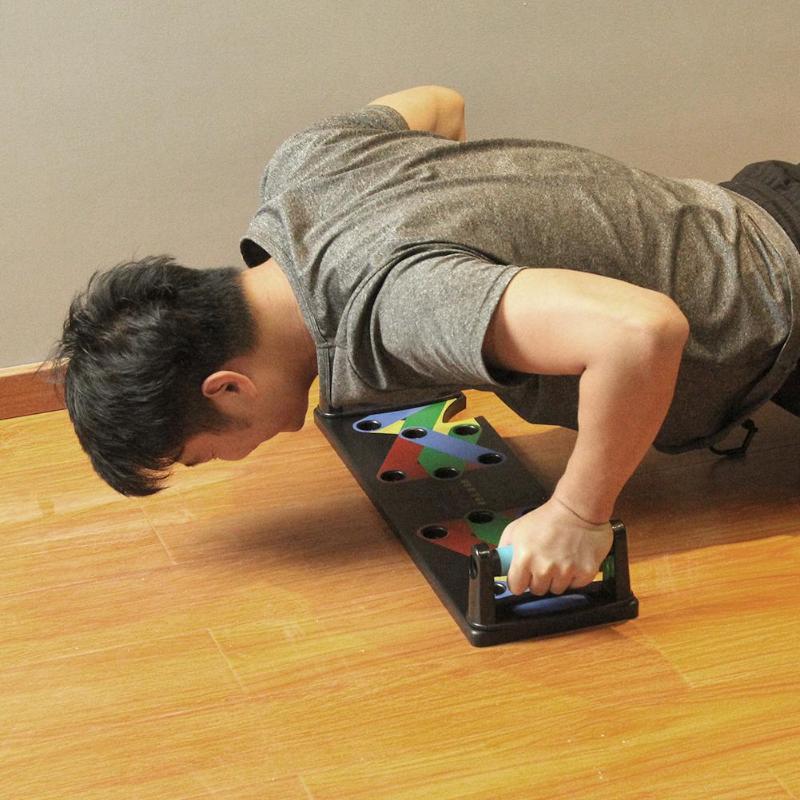 Person using a colorful push-up stand on a wooden floor.