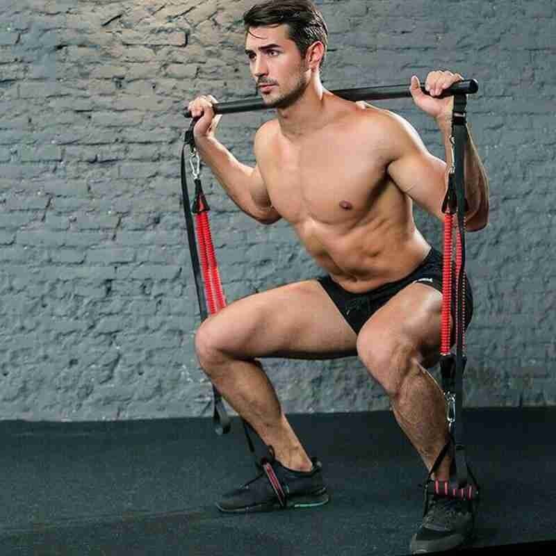 Man exercising with resistance bands against a brick wall.